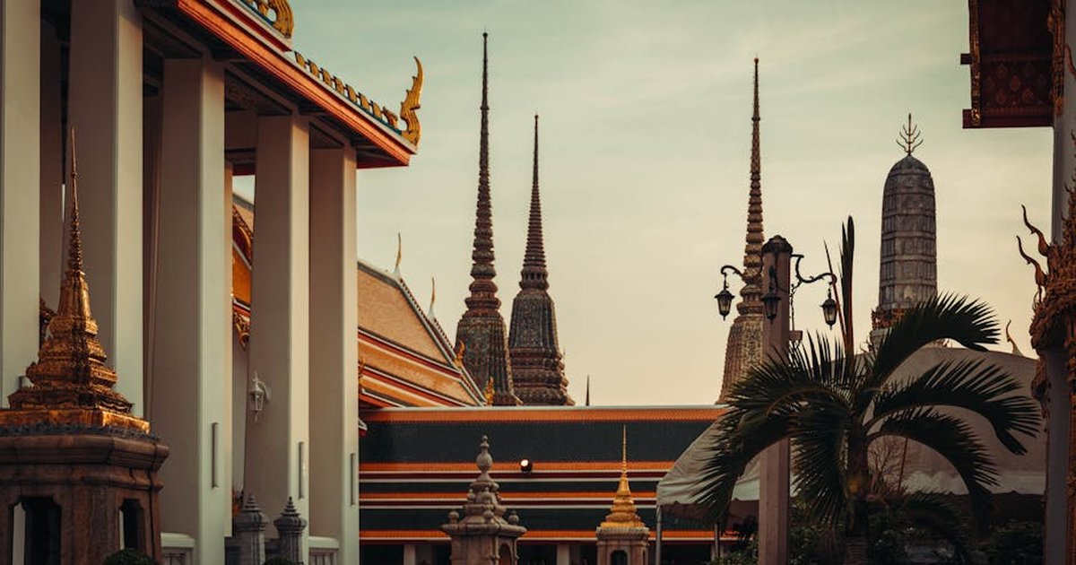 Stunning view of Wat Pho's ornate spires in Bangkok, Thailand at sunset.