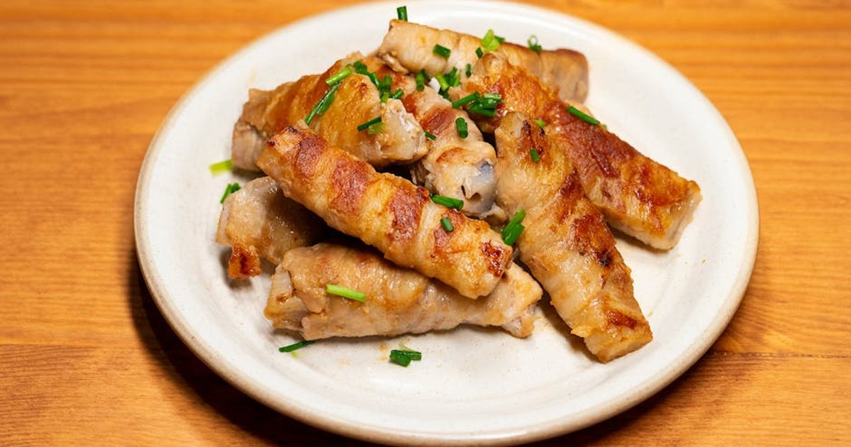Delicious grilled meat rolls garnished with chives, perfect for an Asian-inspired meal.