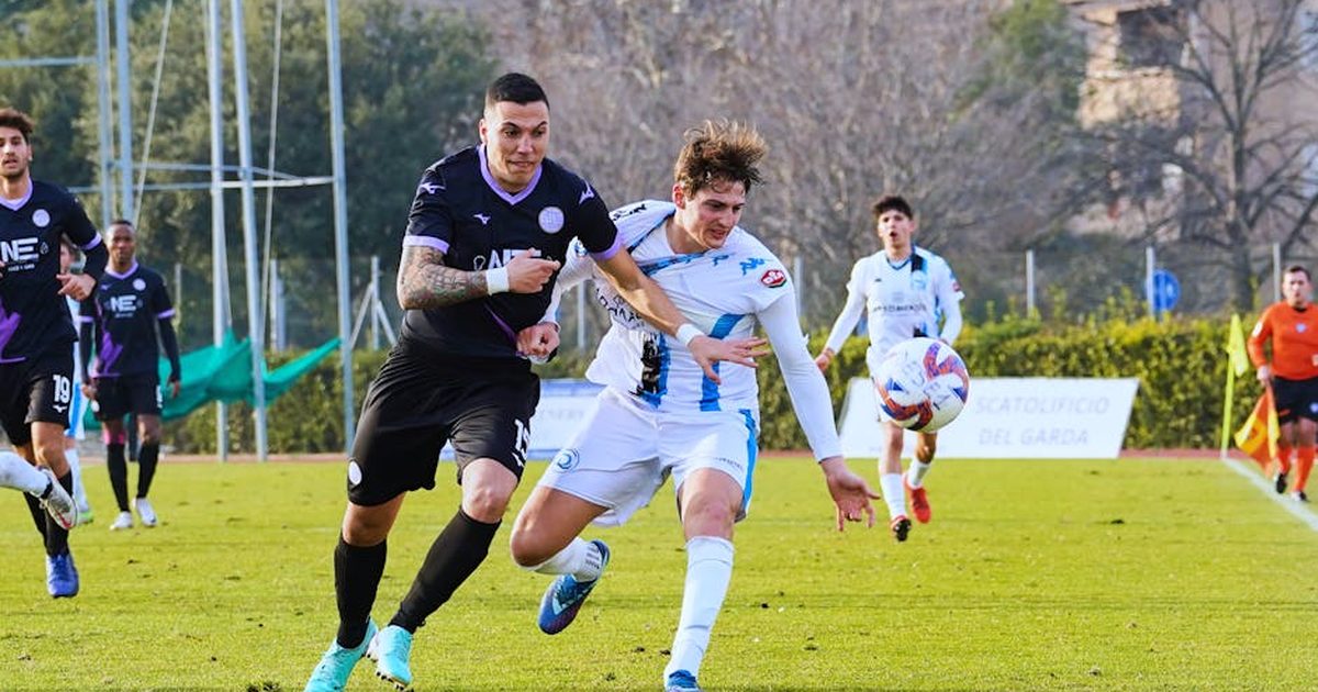 Two soccer players competing fiercely for the ball during an outdoor match.