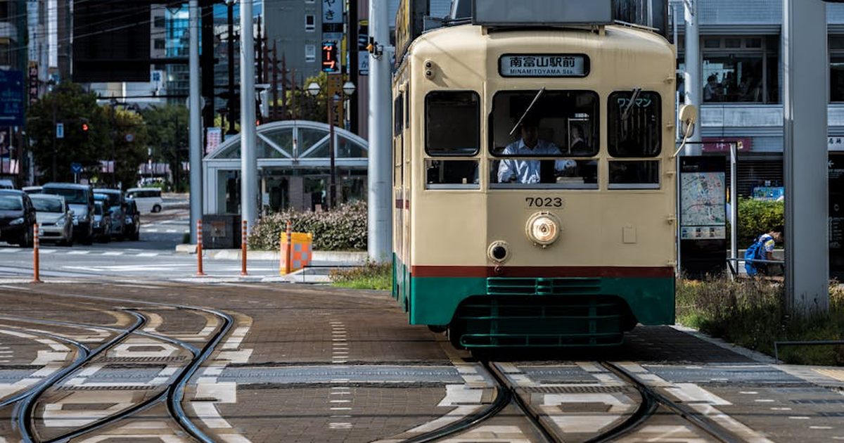 Vintage tram on tracks in Toyama City, Japan, showcasing urban life.