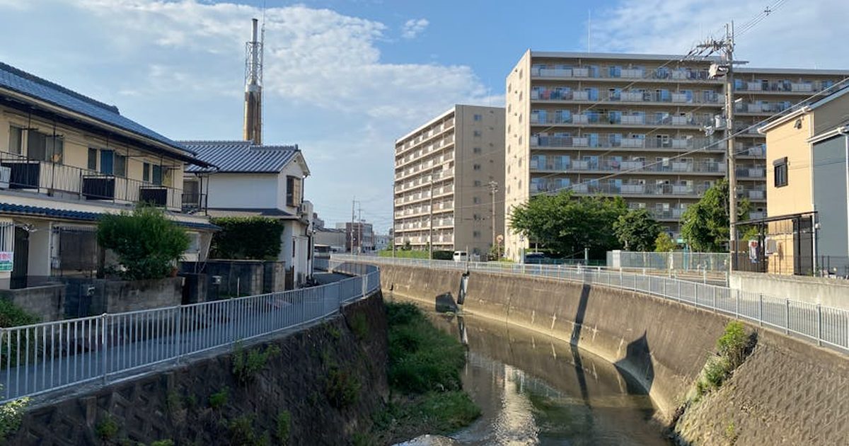 Urban residential scene with apartments near a river in Ikeda, Osaka, Japan.