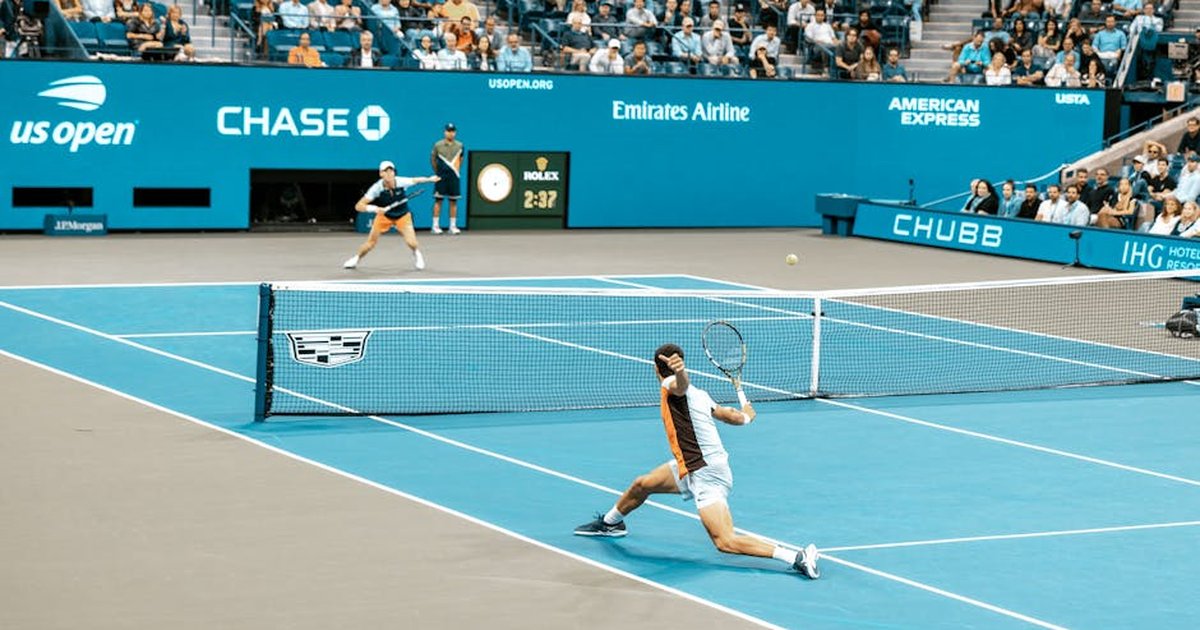 Dynamic scene of players in action at the US Open on a bright tennis court.