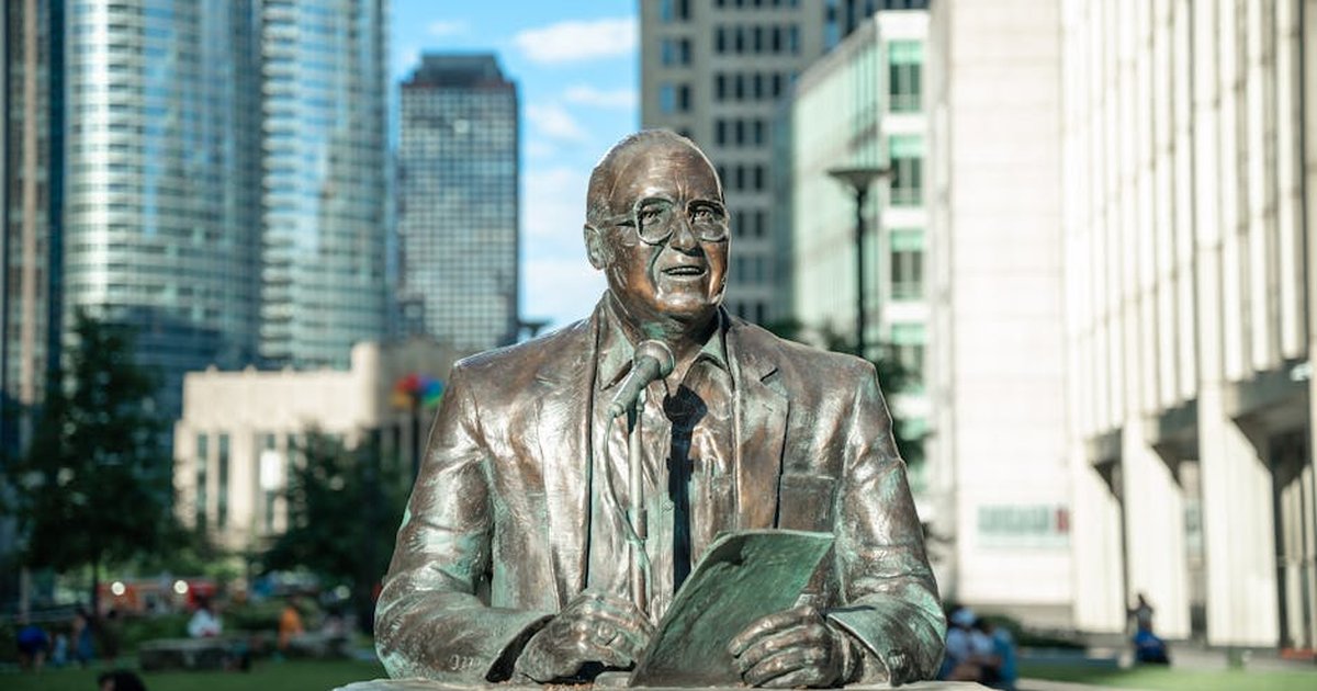 Bronze statue of a man with skyscrapers in a bustling cityscape. Captures urban culture and architectural design.