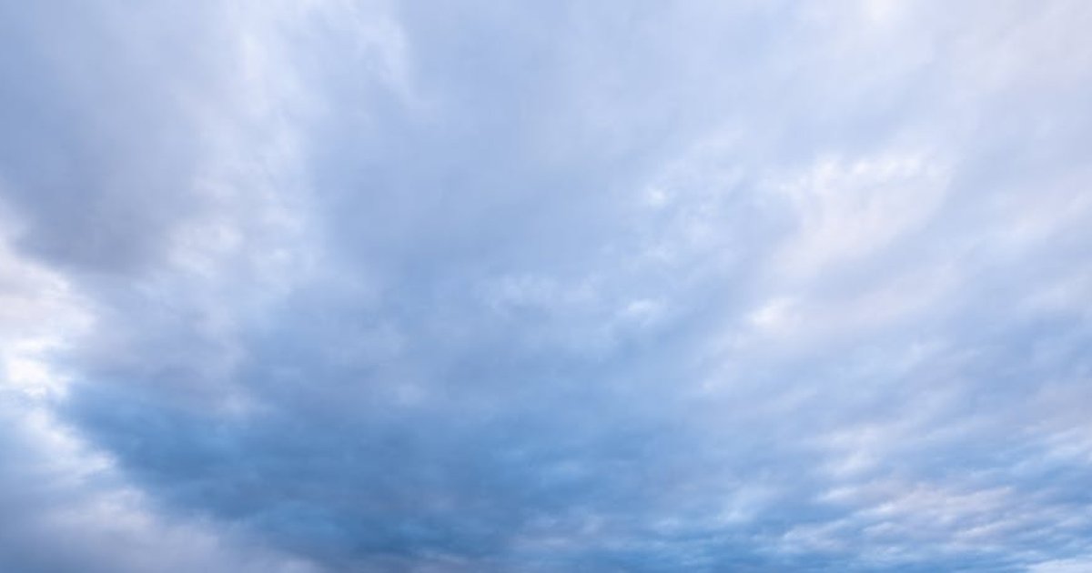 A serene, expansive cloudy sky with soft blue hues and scattered clouds.