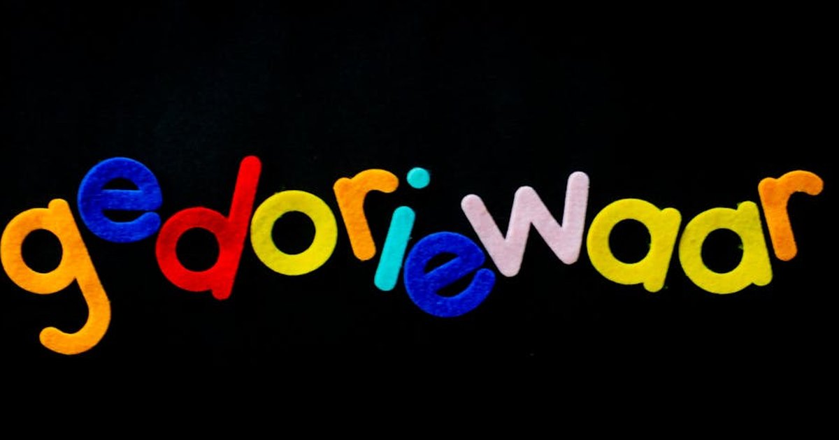 Bright multicolored felt letters spelling a creative word on a black background.