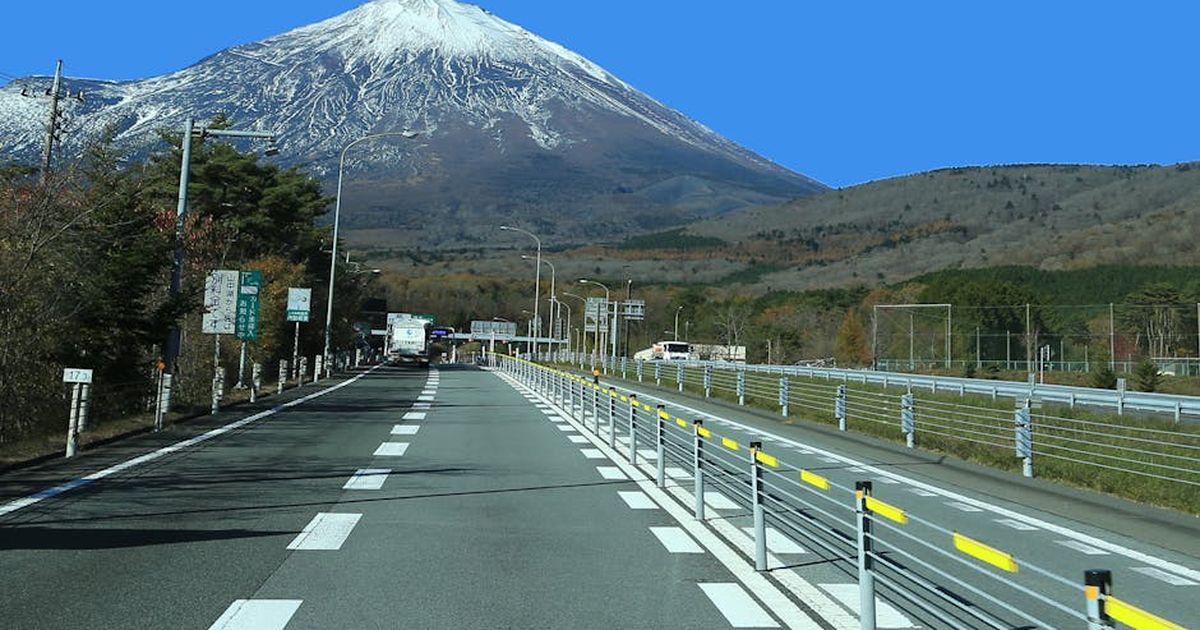 A picturesque road leading to the majestic Mount Fuji in Japan on a clear day.