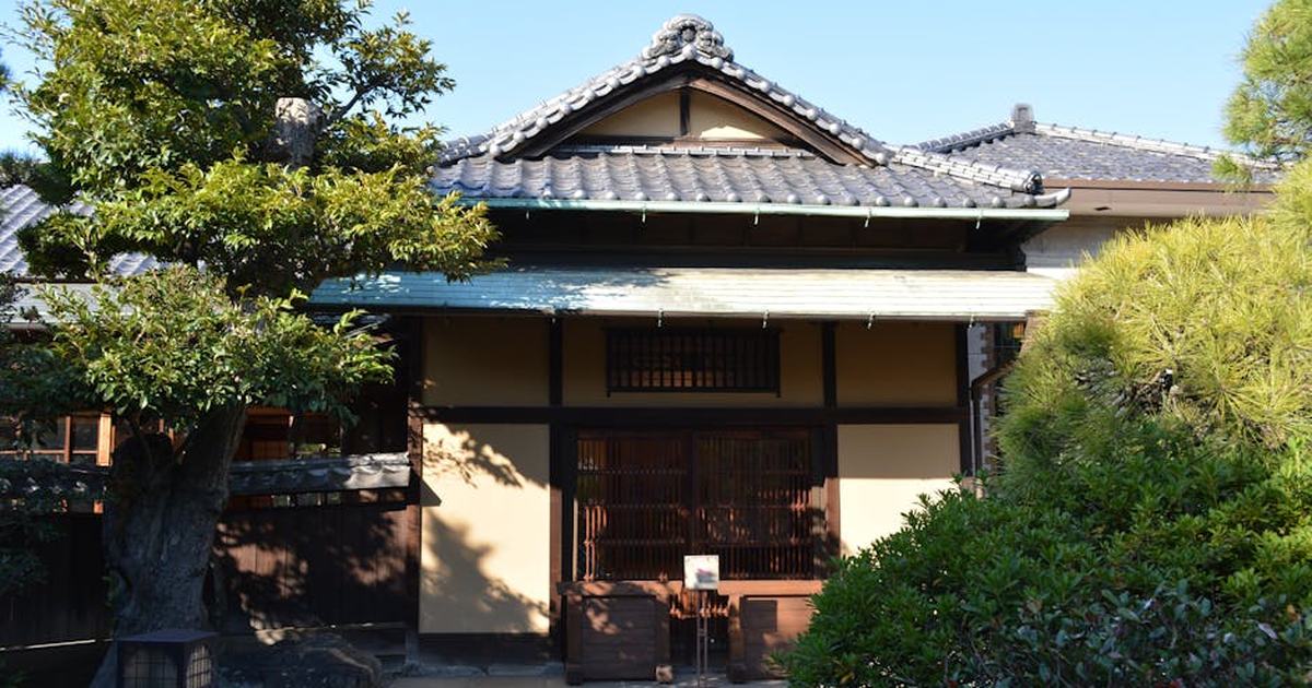 A serene view of a traditional Japanese house surrounded by lush greenery.