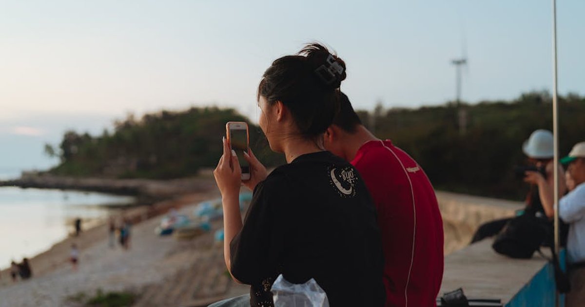 A tranquil scene of people enjoying a sunset at Bình Thuận beach, Vietnam.