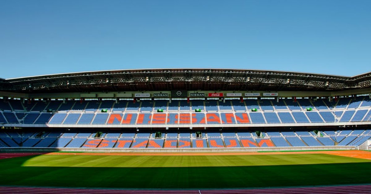 Wide-angle shot of the empty Nissan Stadium in Yokohama, featuring clear blue skies.