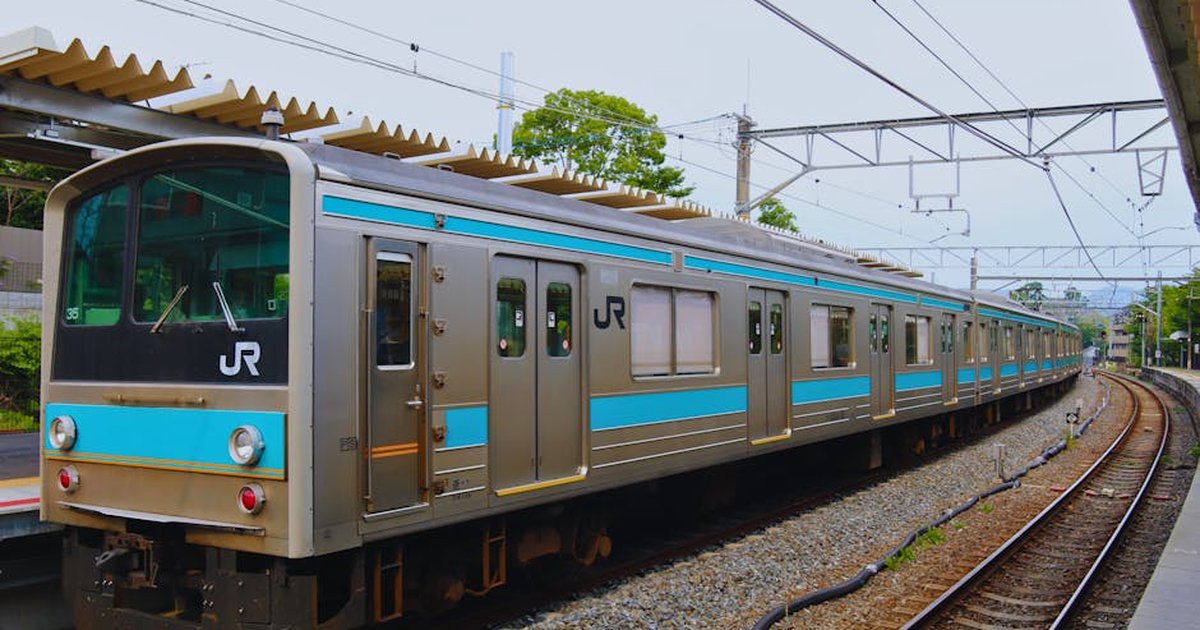 A JR train at a serene Kyoto station, showcasing Japanese transit and architecture.
