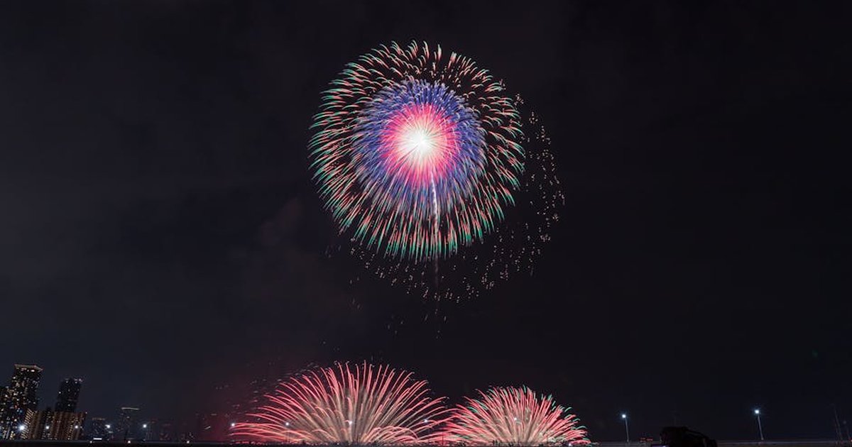 Vibrant fireworks illuminate the night sky in a stunning urban celebration.