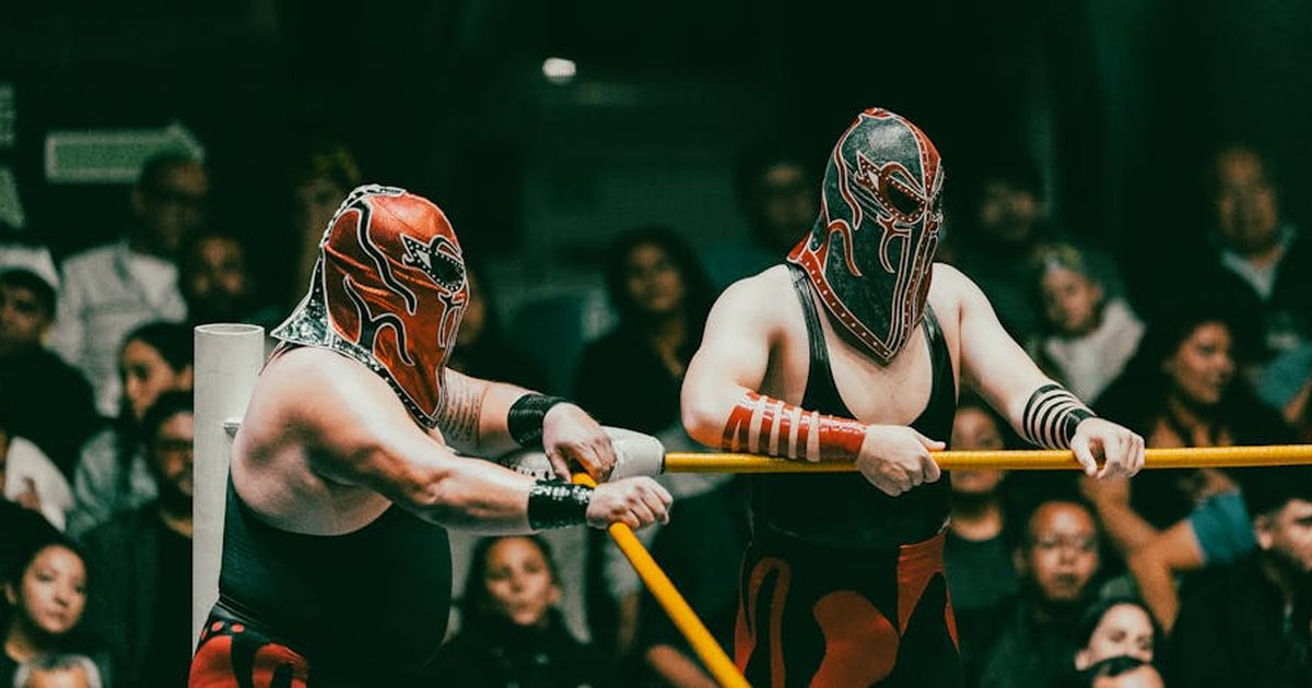 Masked wrestlers compete in an exciting Lucha Libre match before an engaged audience.