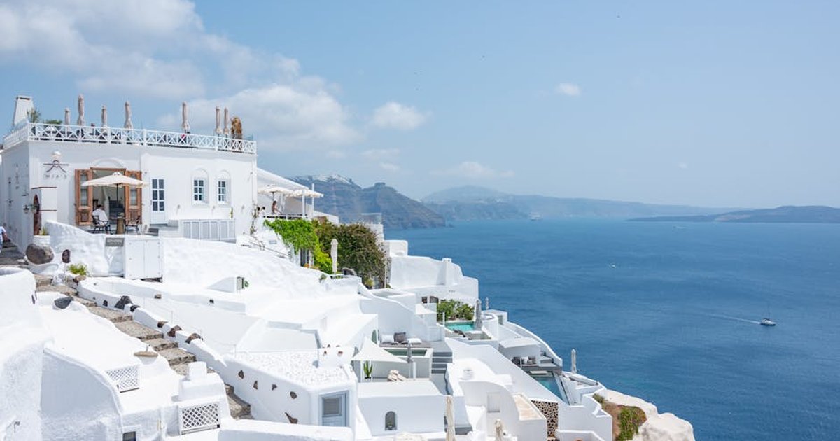 Santorini's iconic white buildings and blue sea create a perfect summer scene ideal for travel enthusiasts.