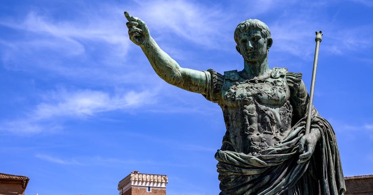 Majestic bronze statue of Julius Caesar in Rome, Italy, with historic architecture backdrop.