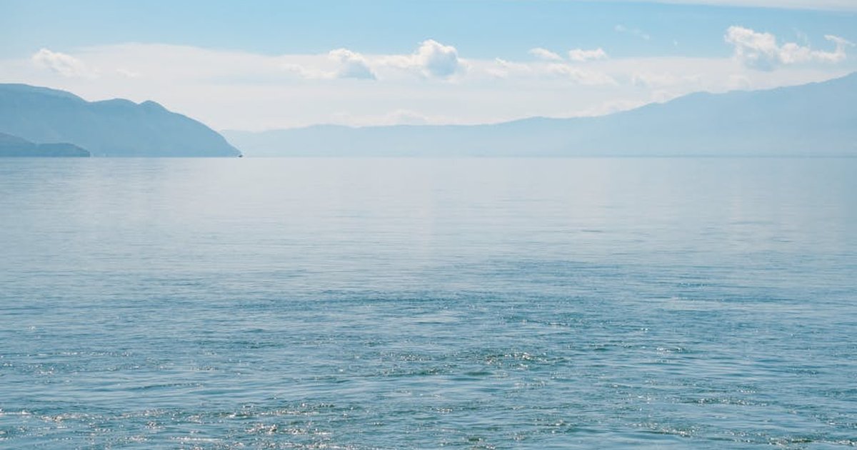 Serene scene of Erhai Lake with mountains and clear sky, Dali, China.