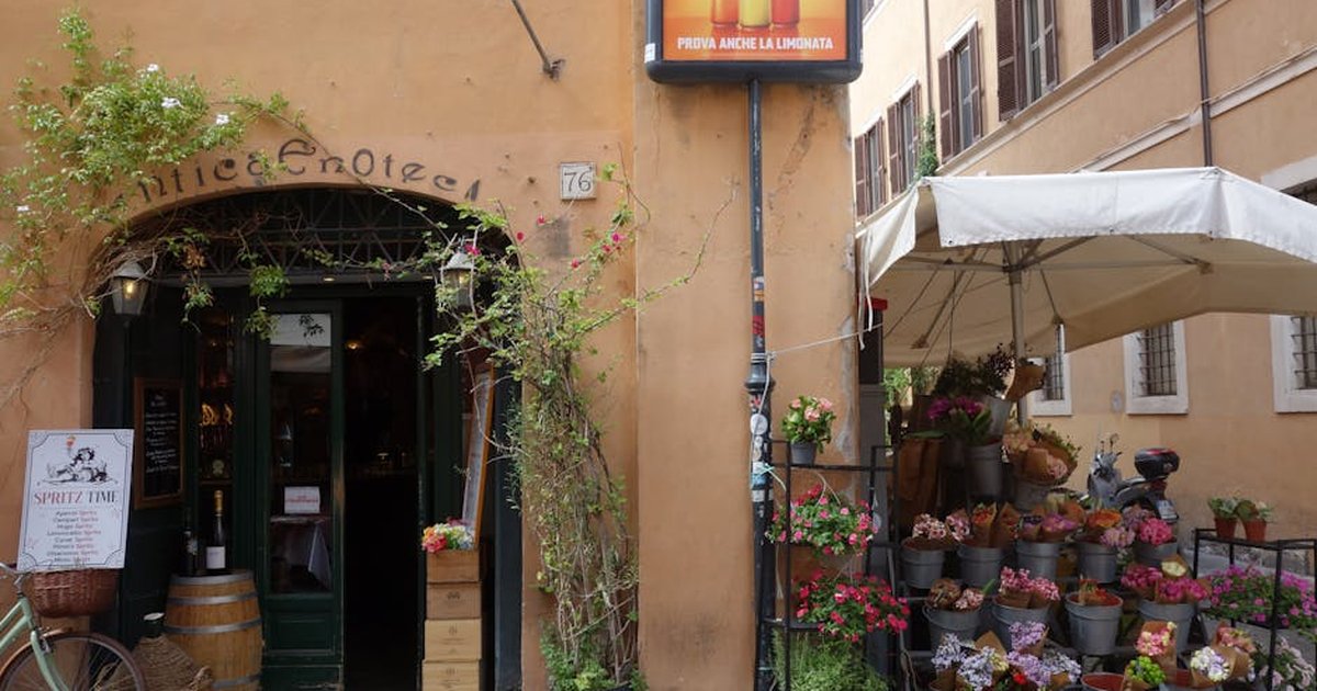 A cozy Italian street corner featuring a flower shop and an enoteca, capturing rustic charm.