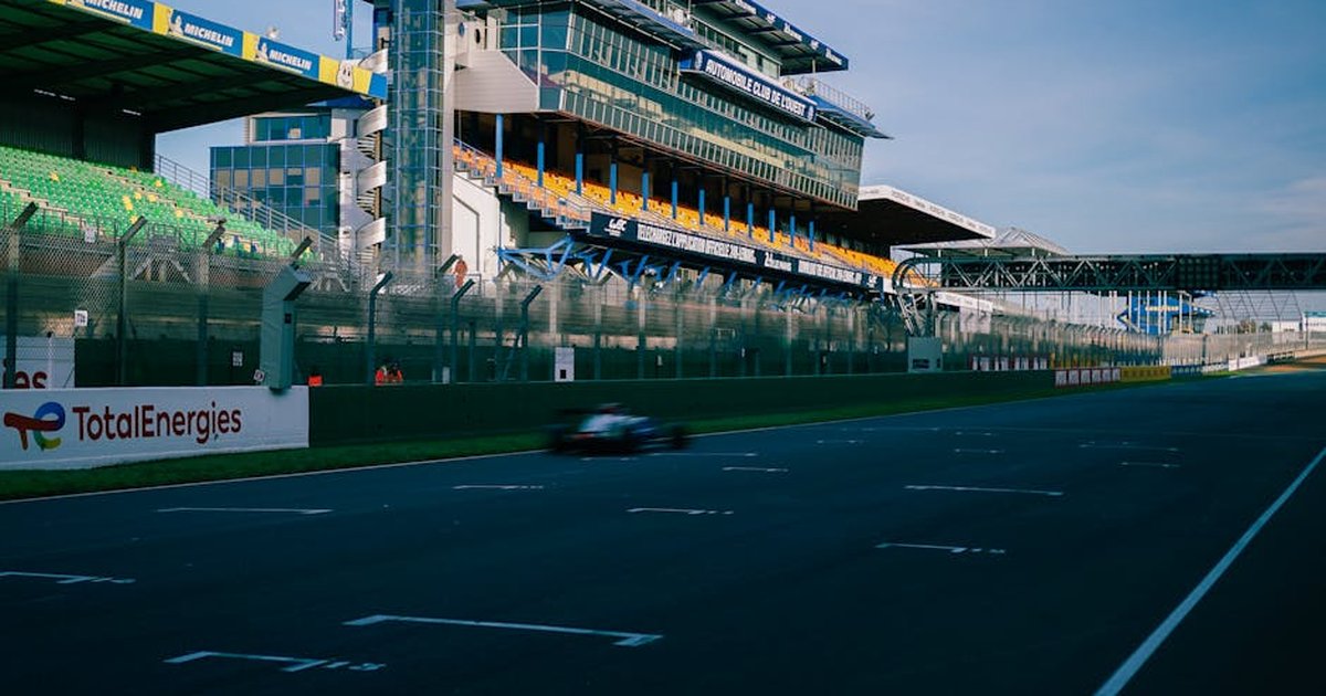 Blurred motion captures the speed of a race car at the iconic Le Mans track.