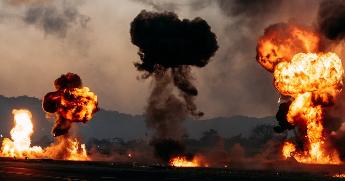 Intense outdoor scene with multiple fiery explosions creating dramatic clouds.