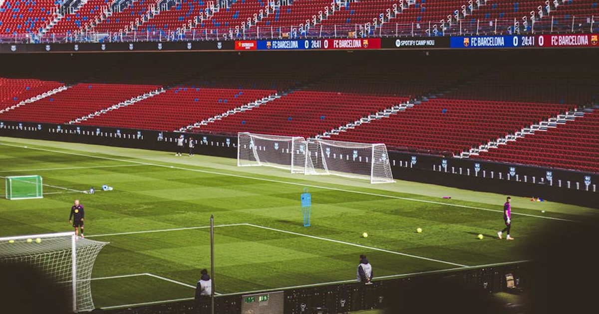 View of empty soccer field at FC Barcelona's Camp Nou with training equipment.