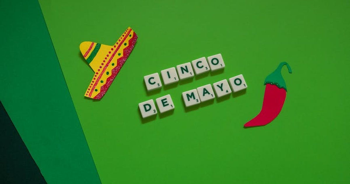A festive Cinco de Mayo arrangement featuring a sombrero, chili pepper, and Scrabble tiles on green.