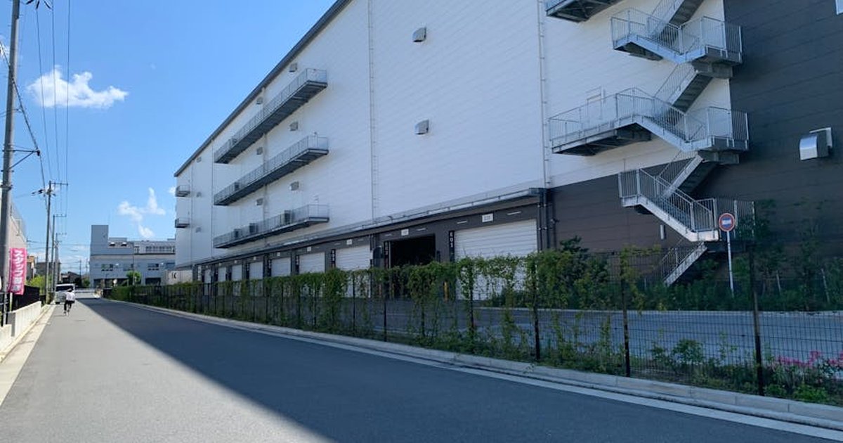 A large industrial building featuring outdoor staircases under a clear blue sky.