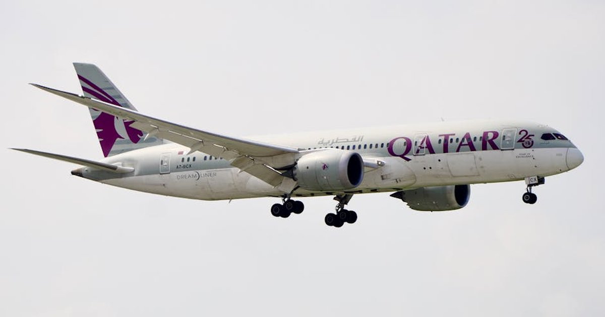 Qatar Airways Boeing 787-9 Dreamliner in mid-air, captured during daytime.