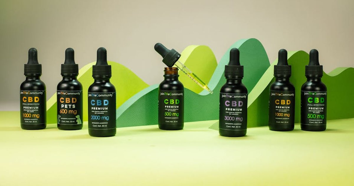 Array of CBD oil bottles with varied dosages on a green backdrop, ideal for wellness themes.