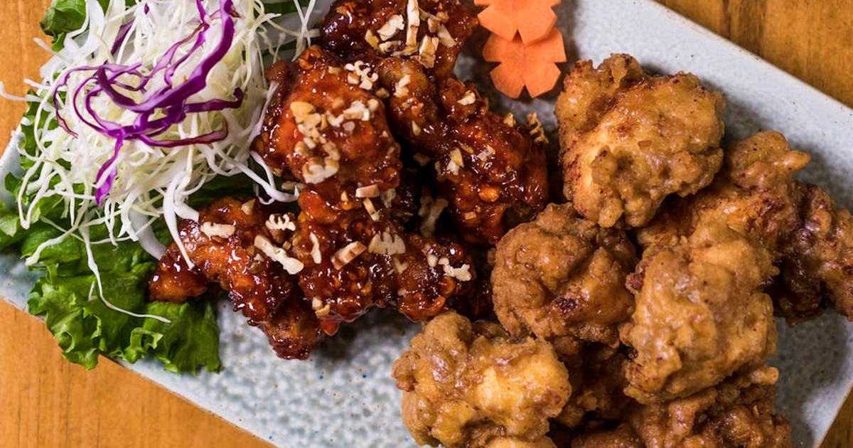 Close-up of a Korean fried chicken platter with garnishes, perfect for food enthusiasts.