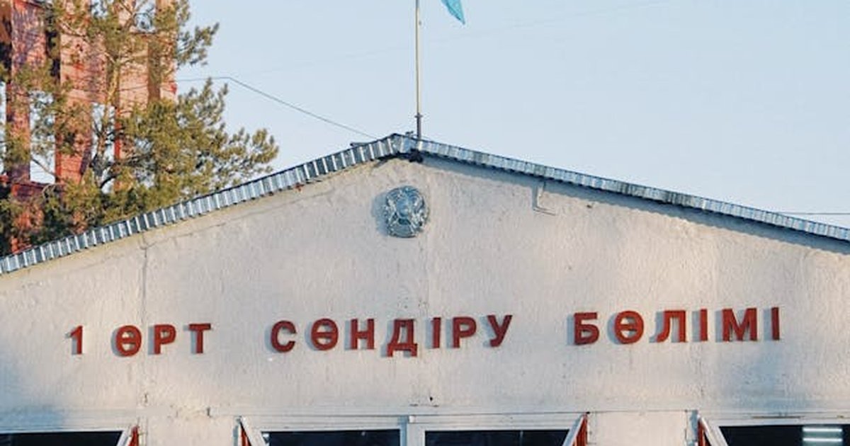 Fire station building in Konaev, featuring Kazakh flag and signage, captured in daylight.