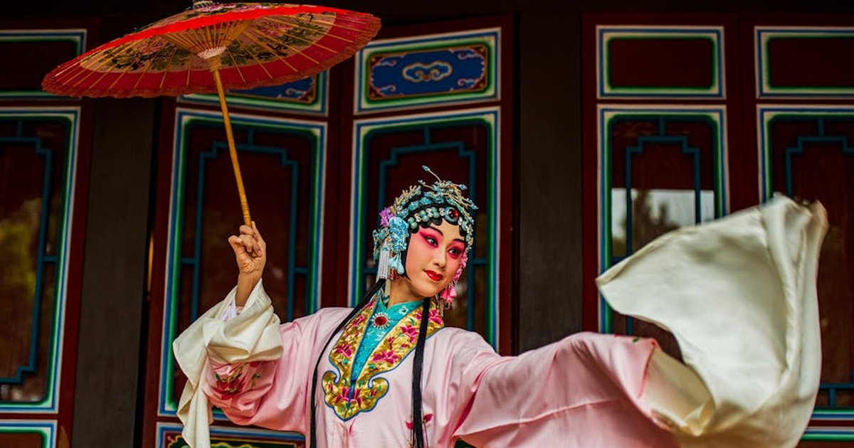 Vibrant portrait of a Chinese opera performer with intricate costume and parasol in Taiwan.