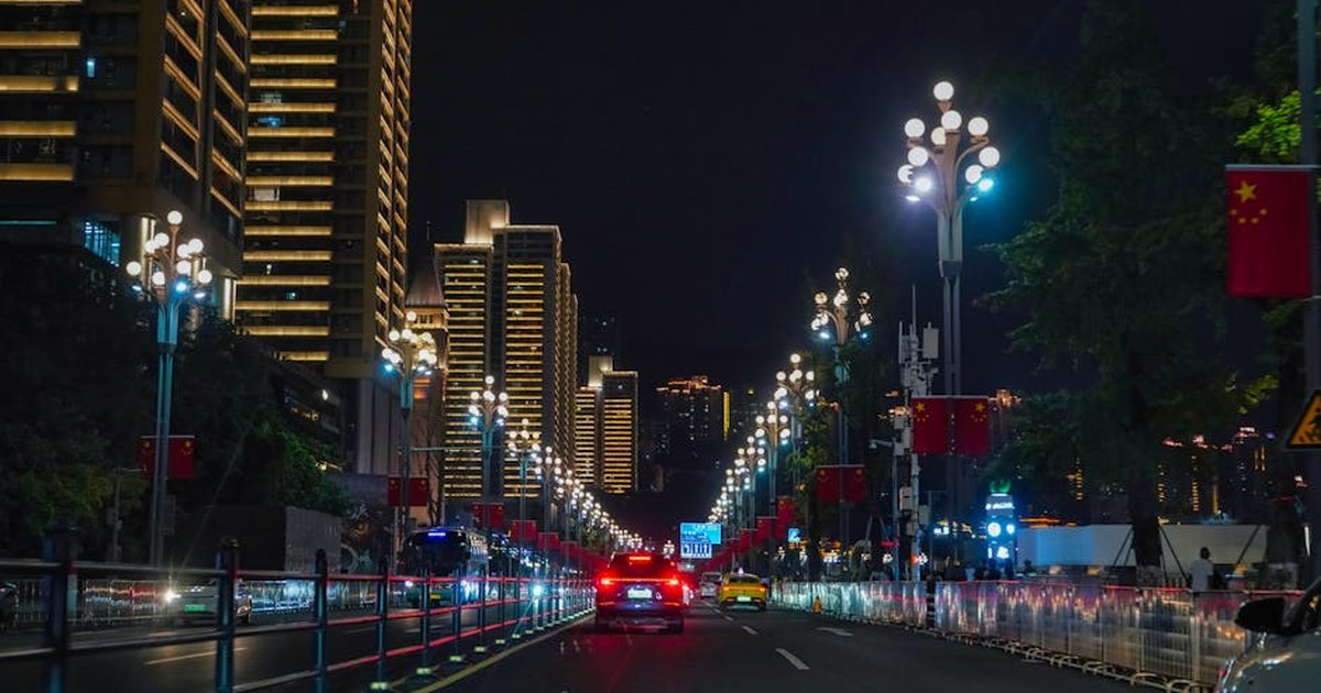 Explore the dazzling night lights in Chongqing with this vibrant cityscape, featuring cars and illuminated buildings.