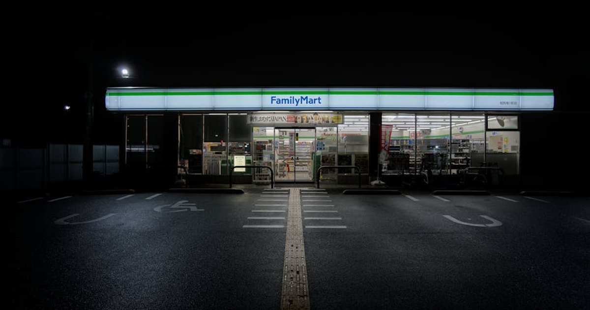 A serene nighttime view of an illuminated FamilyMart convenience store in Kyoto, Japan.