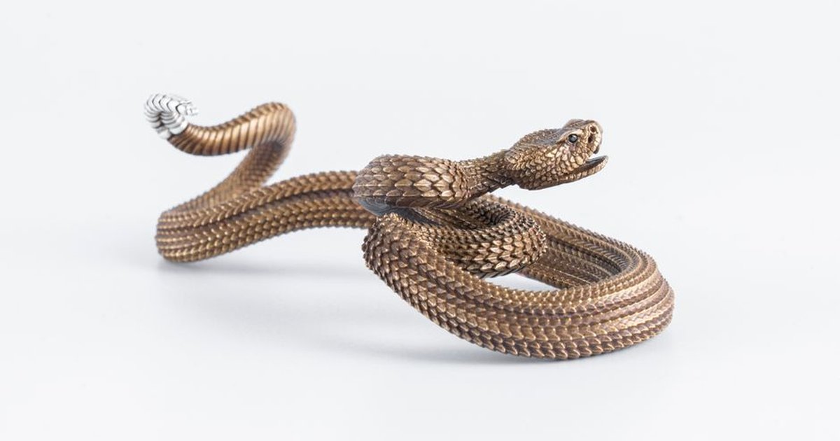 A luxurious and detailed golden snake figurine in a retro spiral design on a white background.