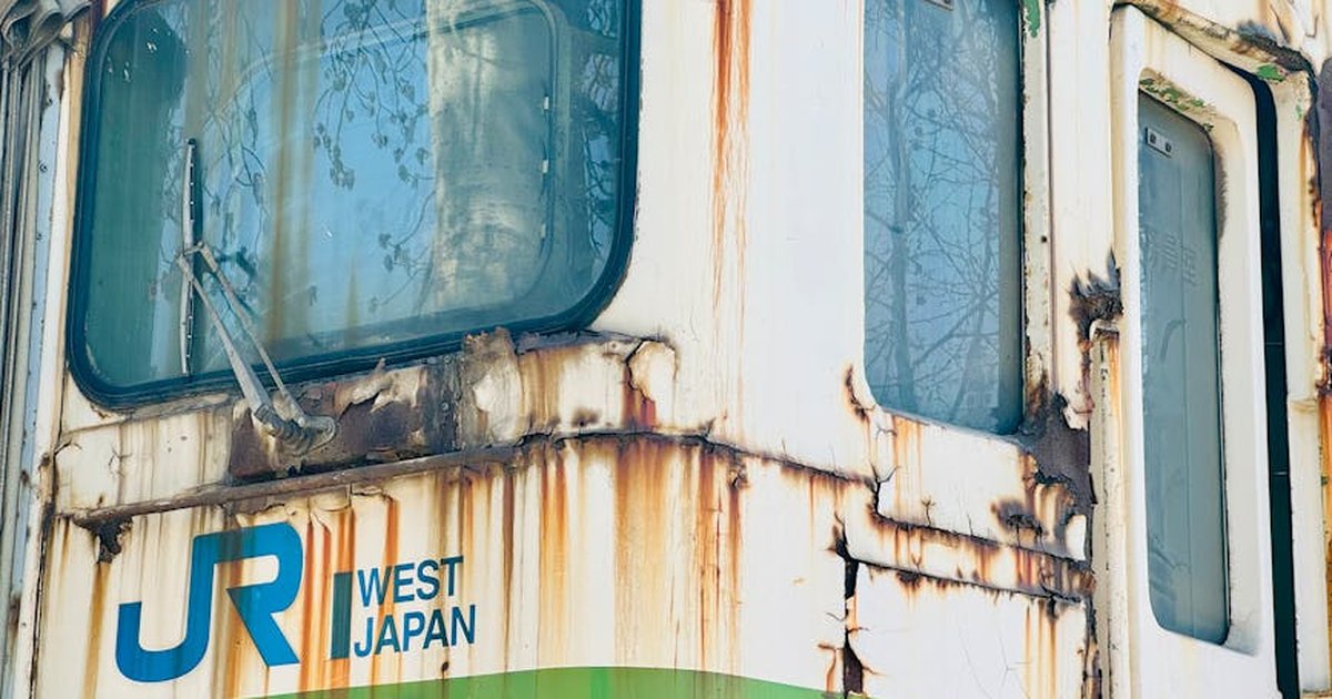 Close-up of a rusting, abandoned train with West Japan markings in Tianjin, China.