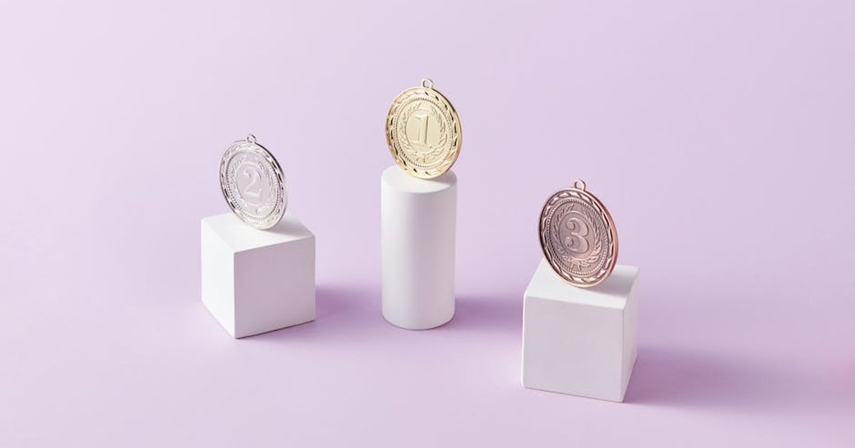 Three medals on podium blocks symbolizing first, second, and third place awards.