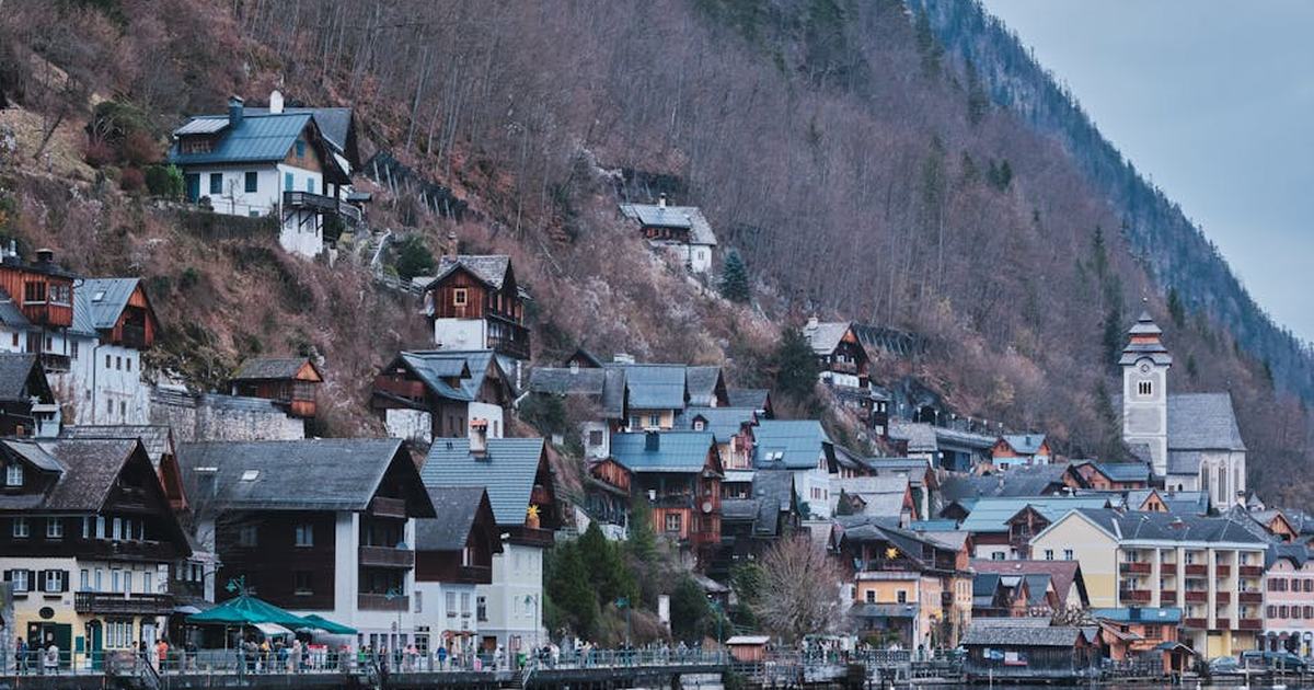Captivating view of Hallstatt's lakeside architecture in autumn, nestled against a hill.