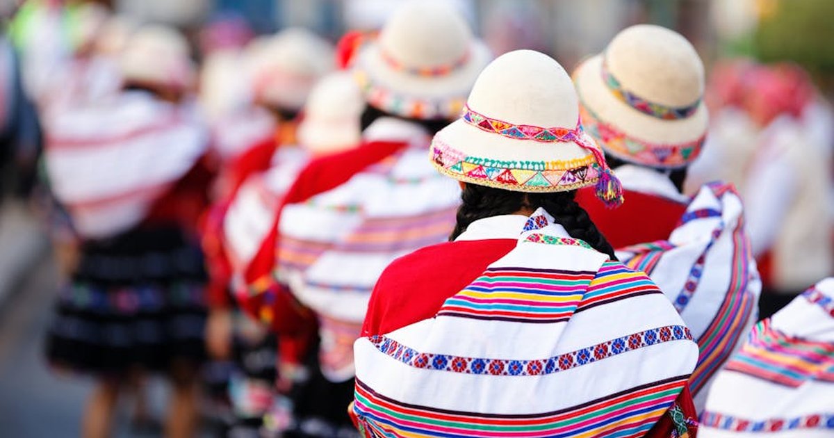 Colorful parade in Cusco, Peru with dancers in traditional costumes, celebrating heritage.