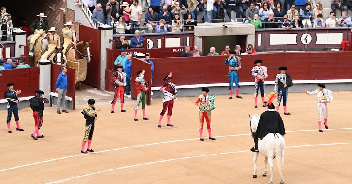 Colorful scene of a bullfighting event at Plaza de Toros, Madrid, filled with vibrant costumes and a lively crowd.