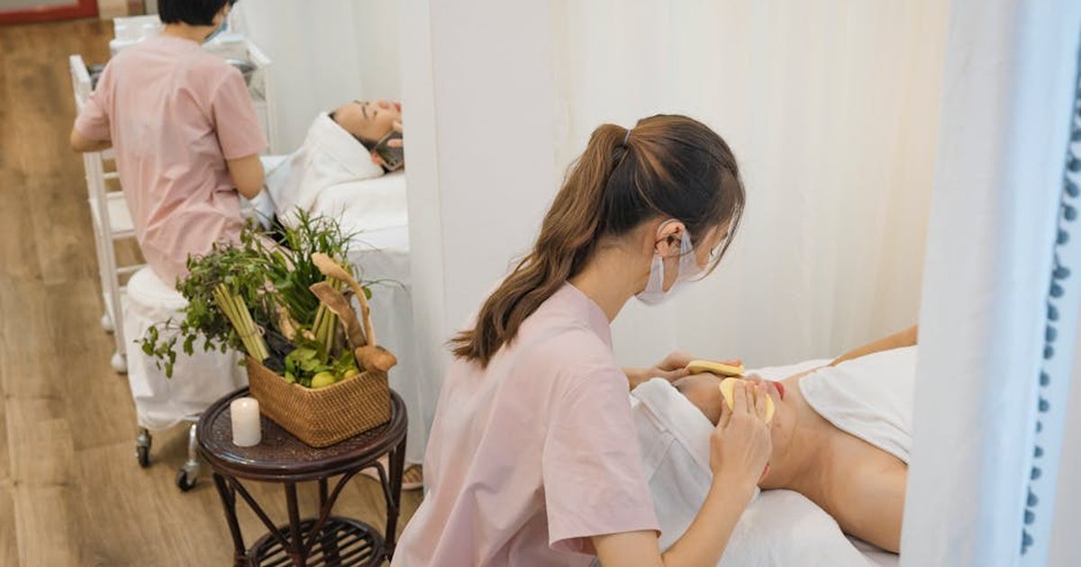 Two professionals provide soothing massage therapy in a calming spa environment.