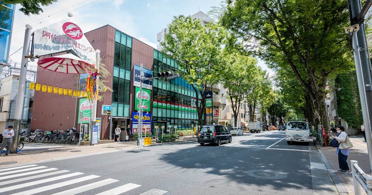 Explore a bustling street in Tokyo, Japan with modern buildings and lively pedestrian activity.
