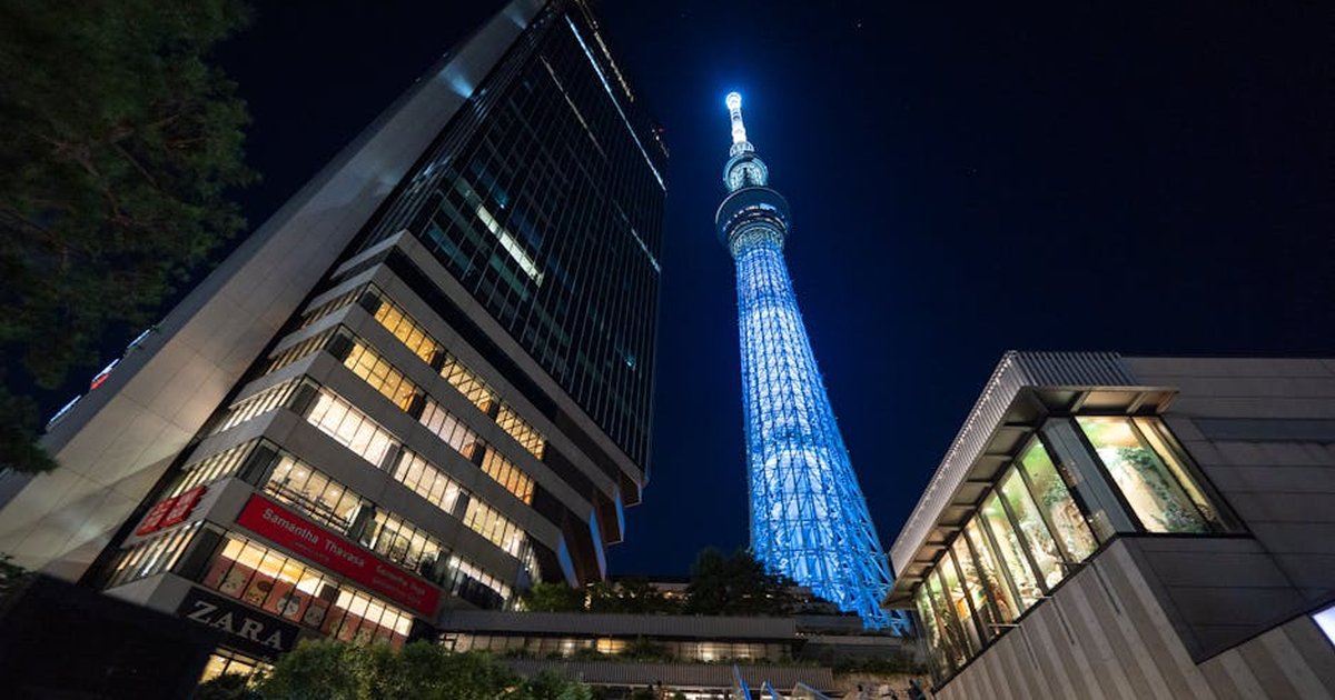 Dramatic night view of the illuminated Tokyo Skytree and surrounding cityscape.