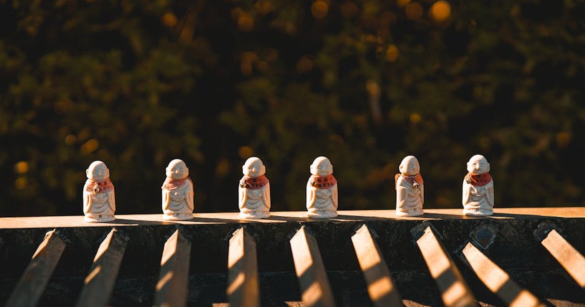Small Buddha statues on a temple roof in Tokyo, Japan, during sunset.