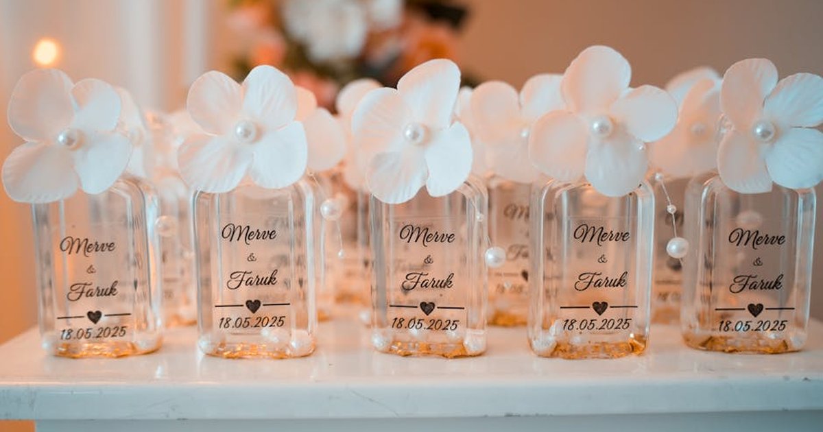 Chic wedding favor bottles with white flowers and personalized labels for Merve & Faruk's event.