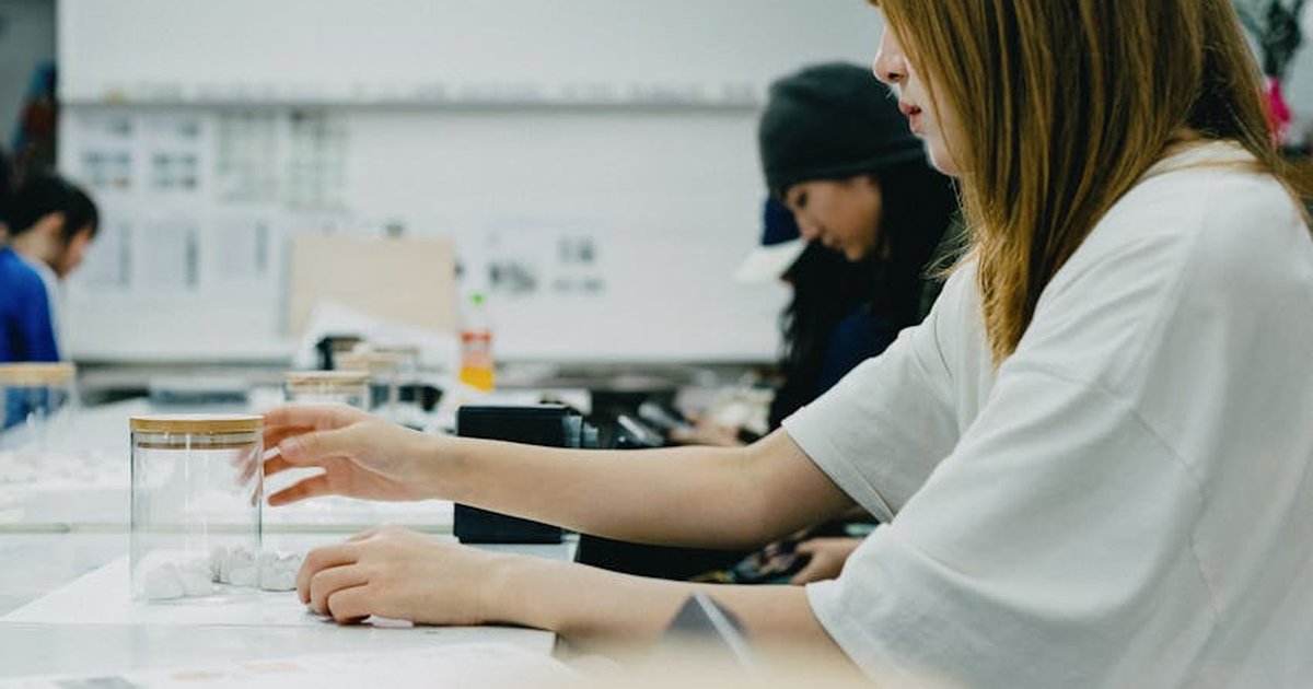 A group of art students in Tokyo focus on a creative workshop, working with drawing materials.