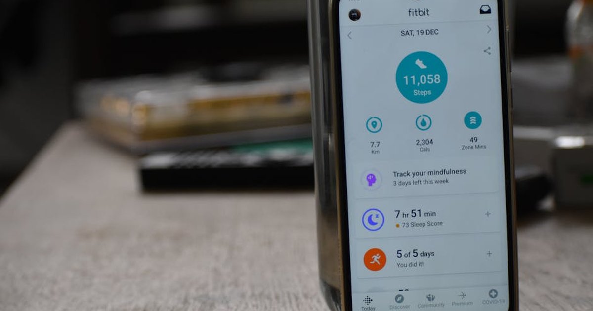 Close-up of a smartphone displaying a fitness tracking app with health statistics.