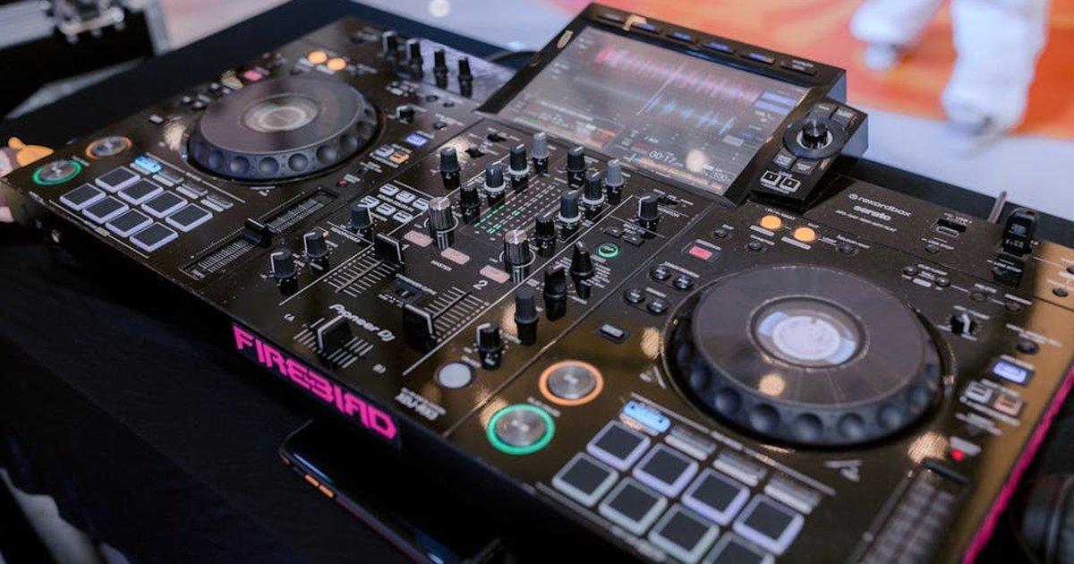 Close-up of a modern DJ controller setup at a lively indoor event.