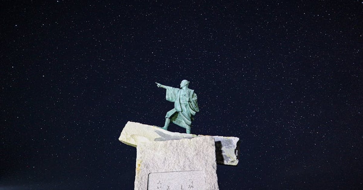 The Taiki statue at Cape Zanpa pointing under a starry night sky in Japan.