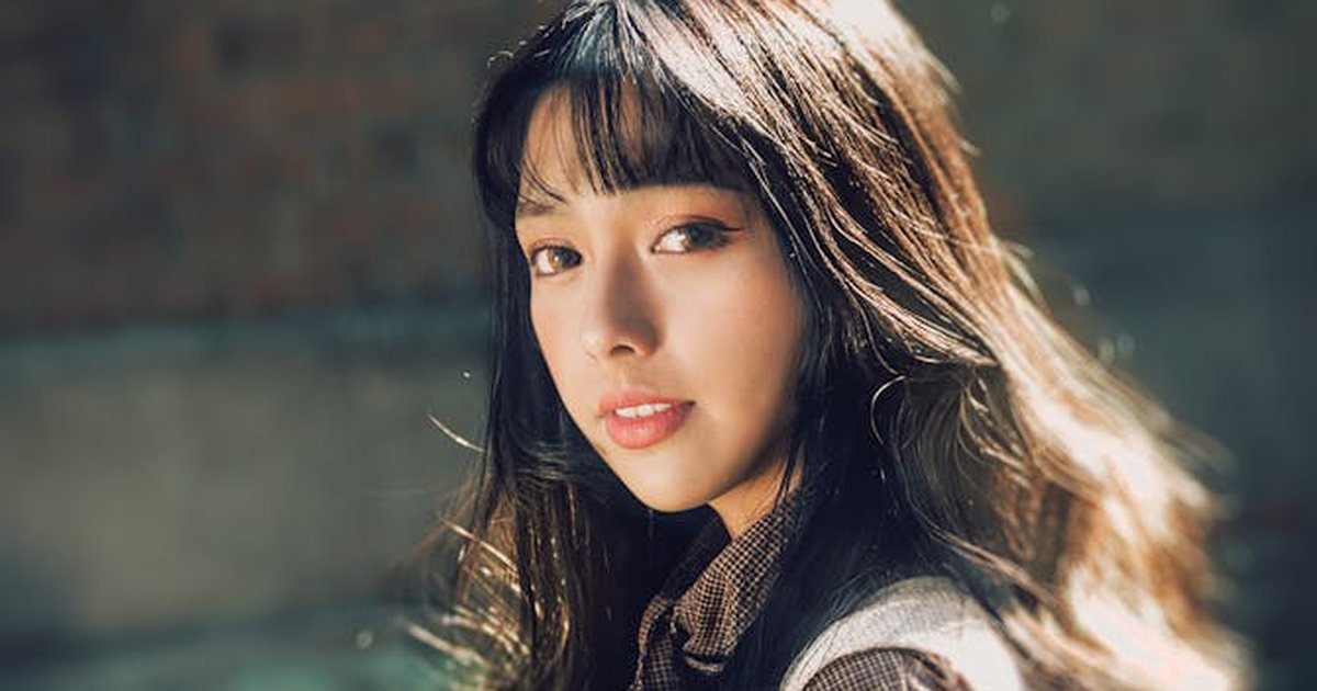Portrait of a young woman with long hair, captured outdoors in natural light.