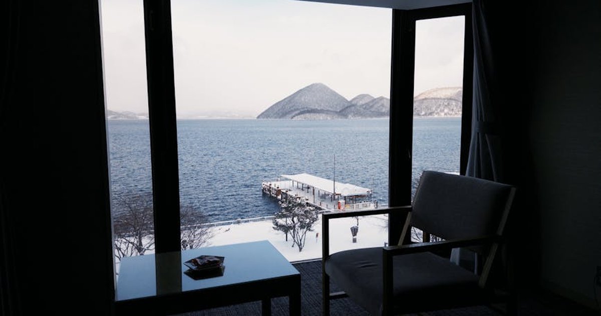 A beautiful winter view of Lake Toya from a cozy room with open window.
