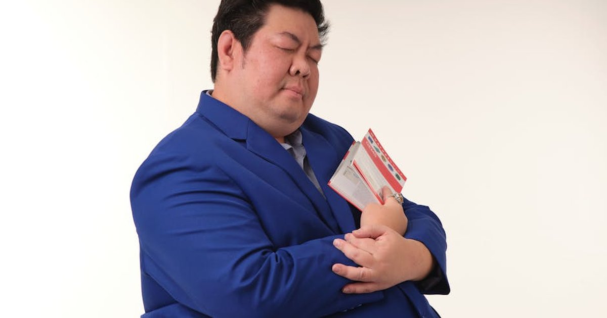 Man in a blue suit peacefully holding a closed book, conveying tranquility.